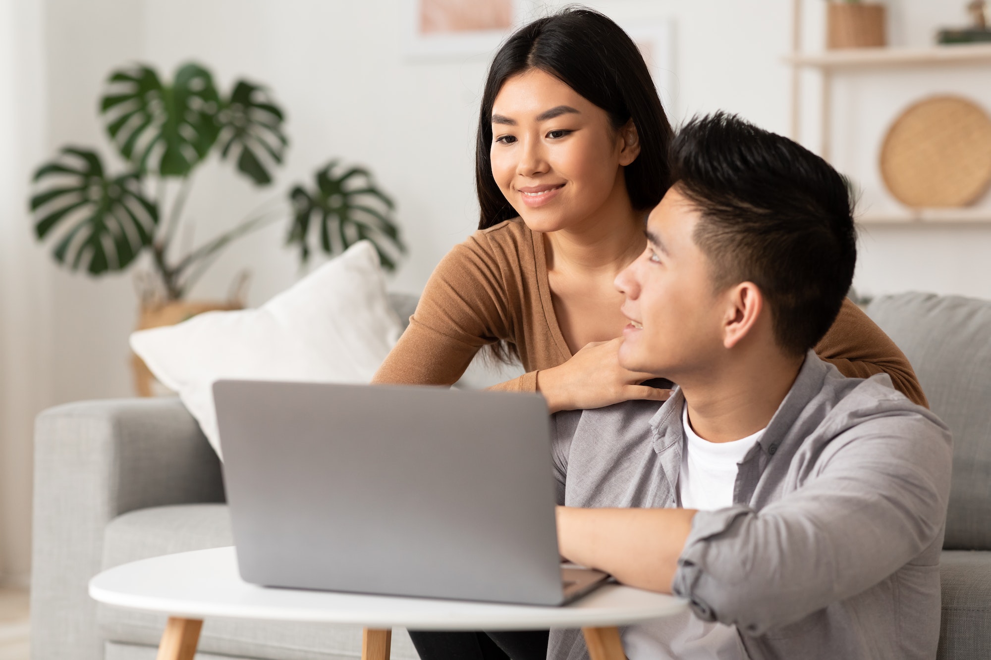 Young filipino couple using laptop at home